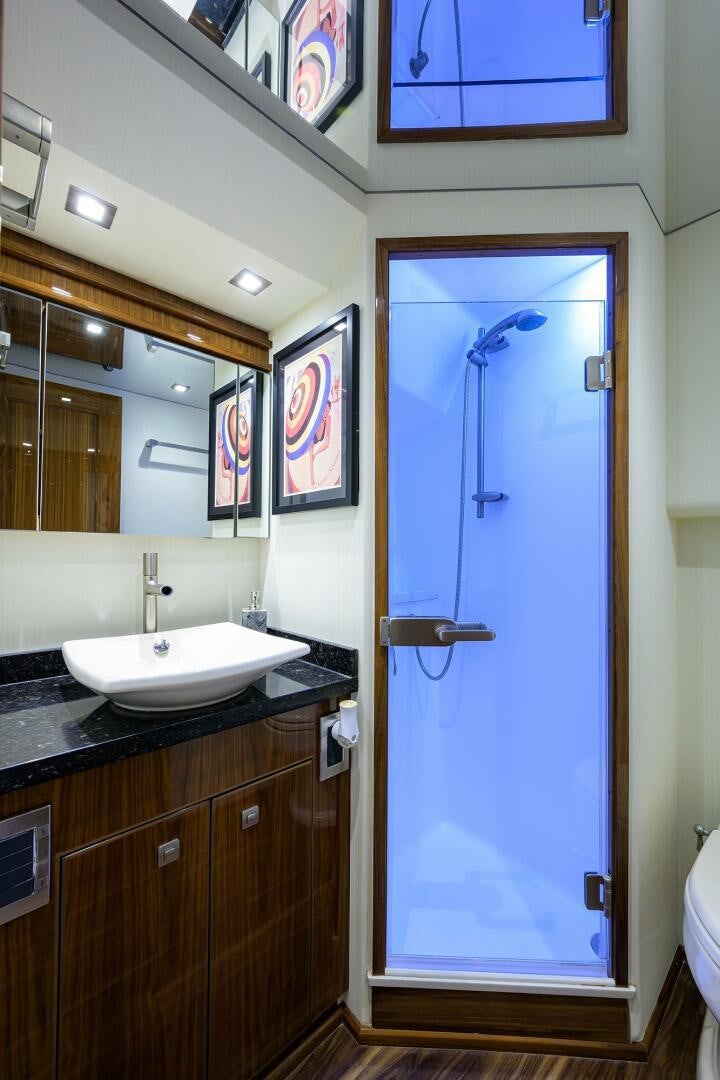 a bathroom with a blue shower door aboard 80' VIKING Yacht for Sale
