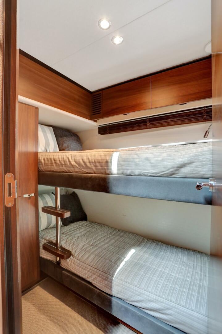 a bed with a wooden headboard aboard REAL SLICK Yacht for Sale