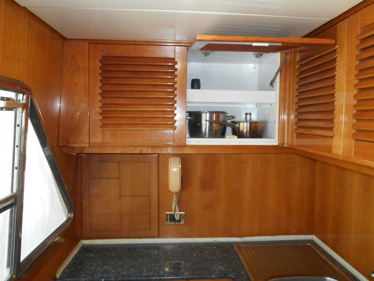 a kitchen with wooden cabinets aboard LADY C Yacht for Sale