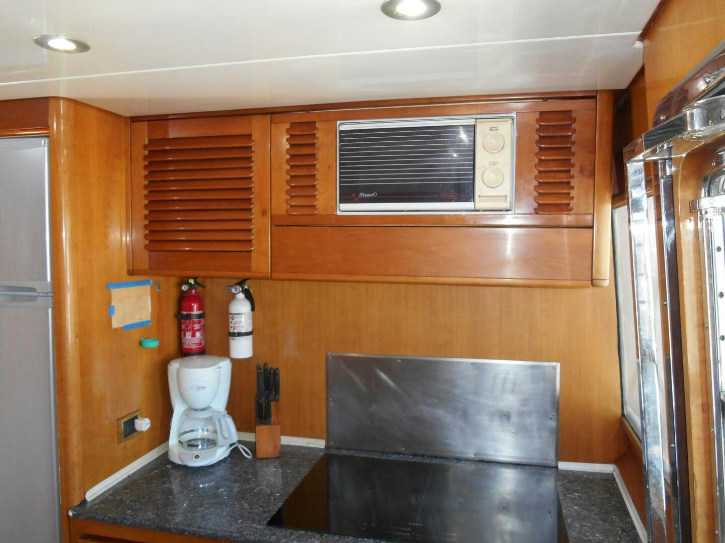 a kitchen with a white pitcher and wooden cabinets aboard LADY C Yacht for Sale