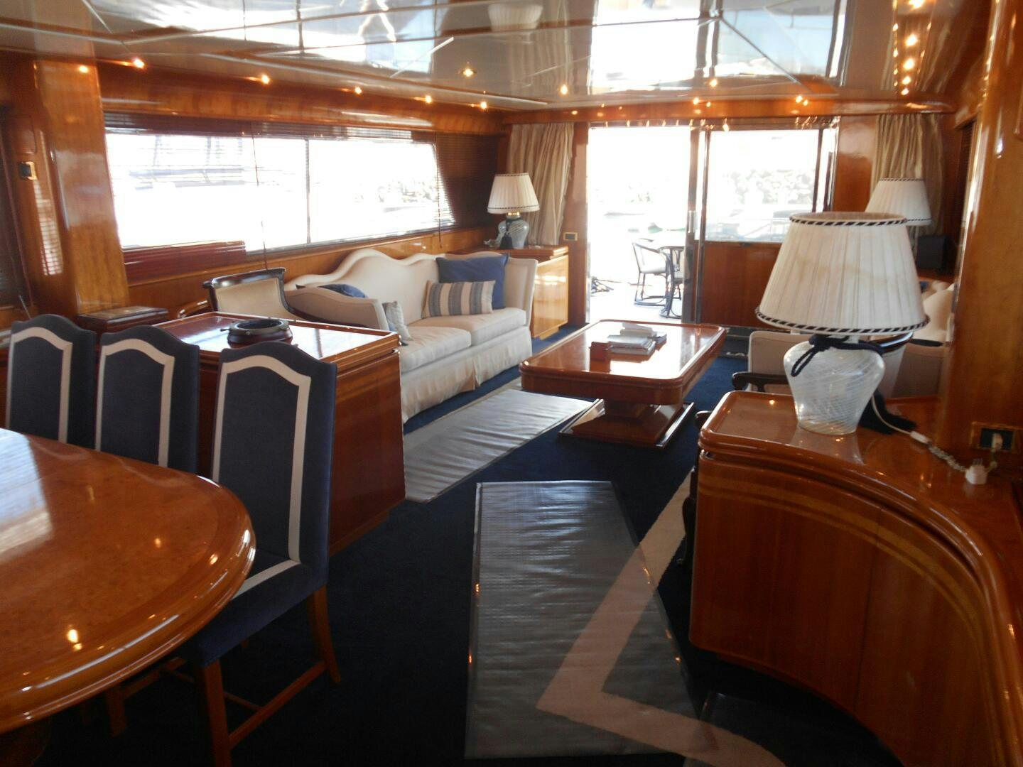 a room with a couch and a table and a lamp aboard LADY C Yacht for Sale