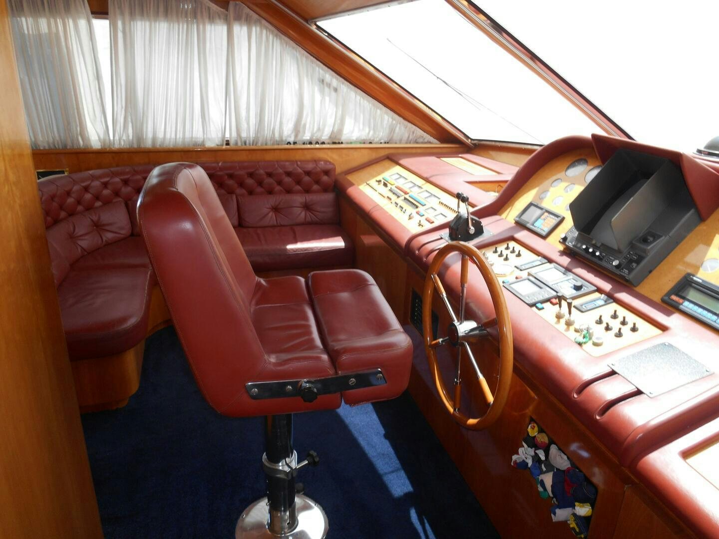 a red chair in a room aboard LADY C Yacht for Sale