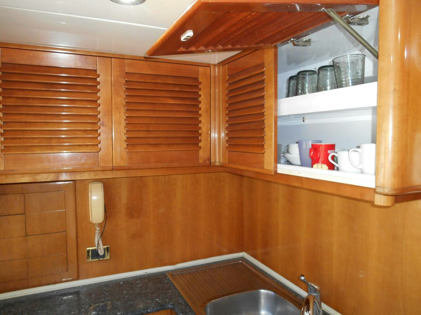 a kitchen with wooden cabinets aboard LADY C Yacht for Sale