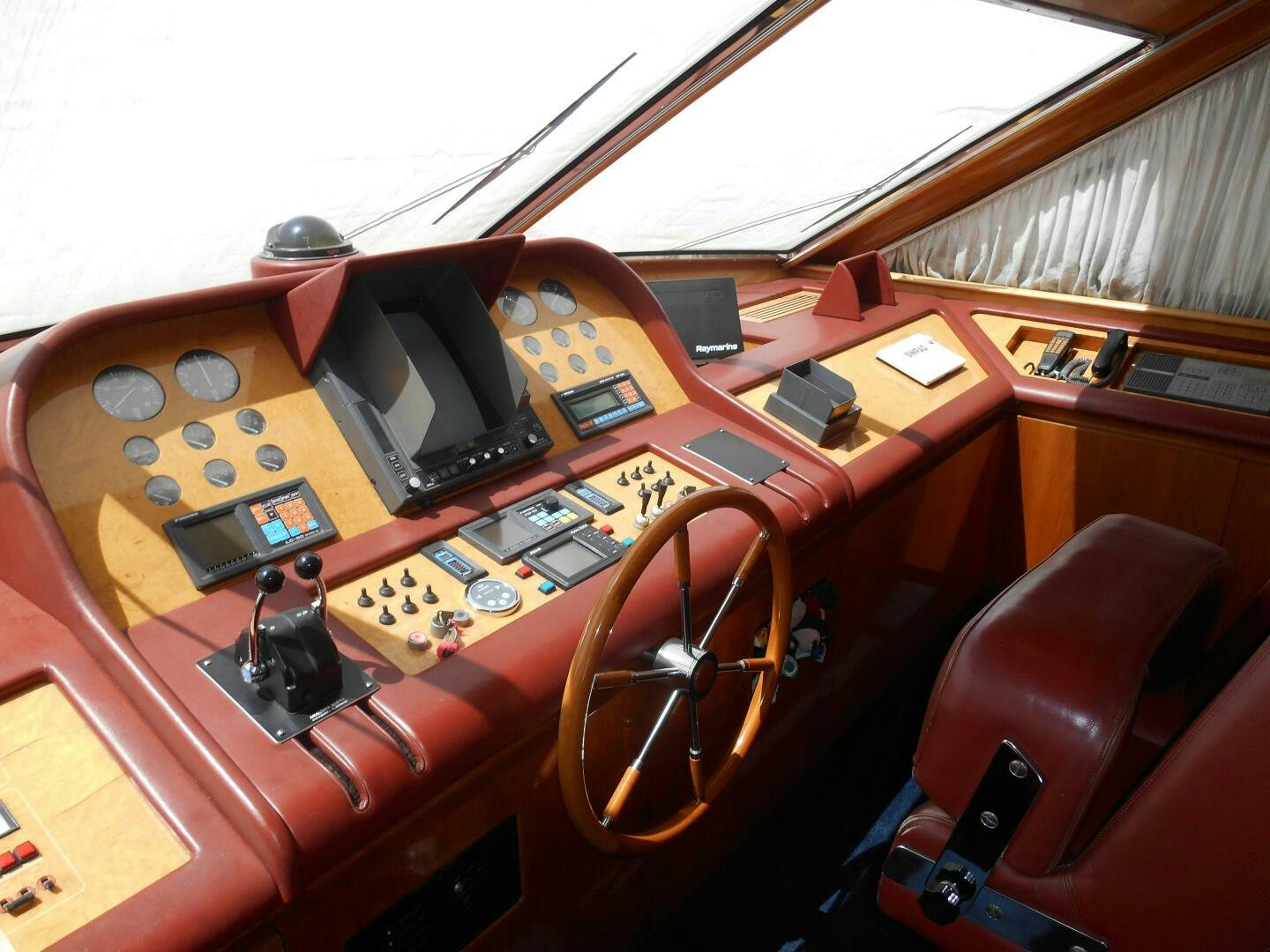 a wooden desk with a computer and other electronics on it aboard LADY C Yacht for Sale