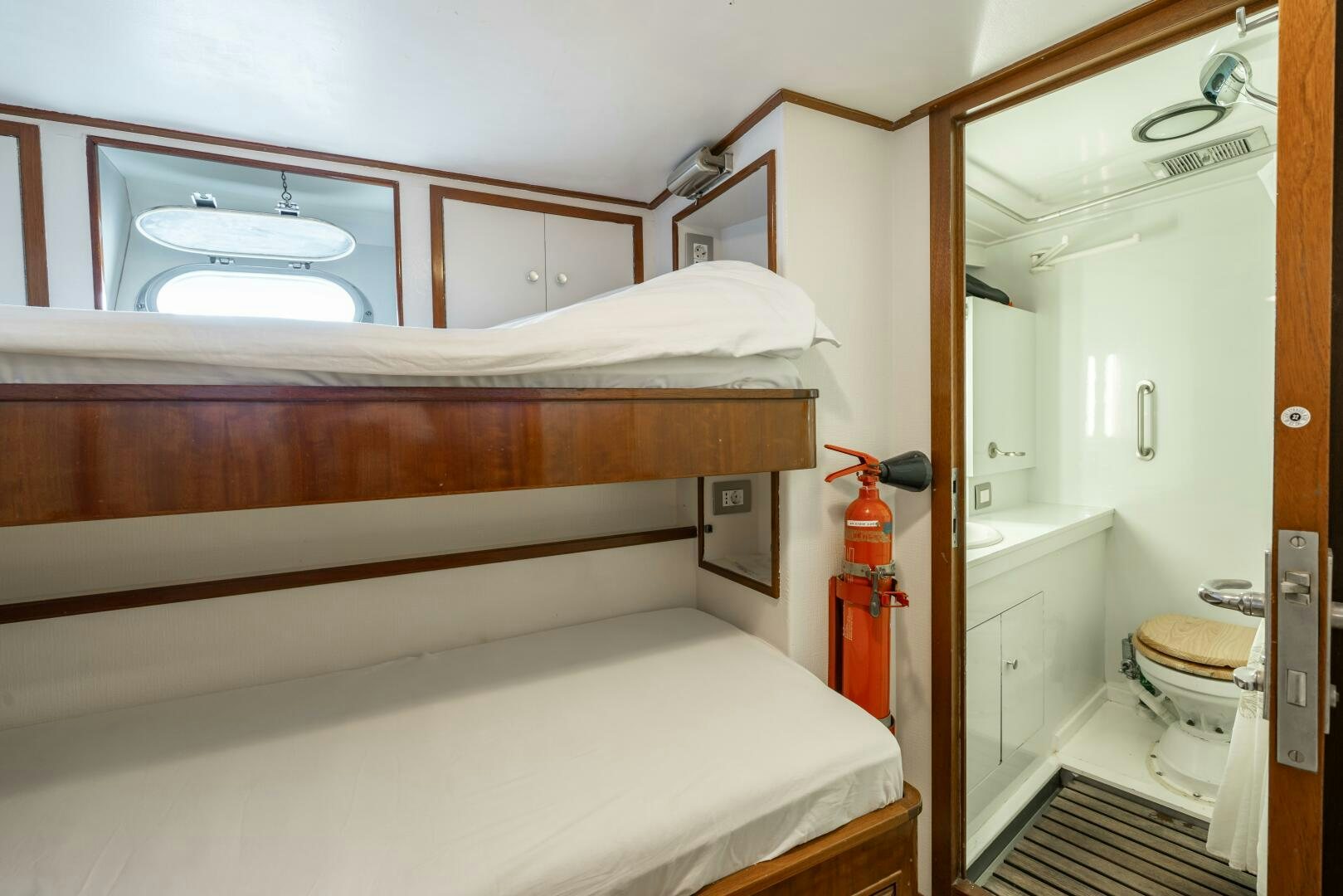 a bedroom with a bed and a mirror aboard BLUEMAR II Yacht for Sale