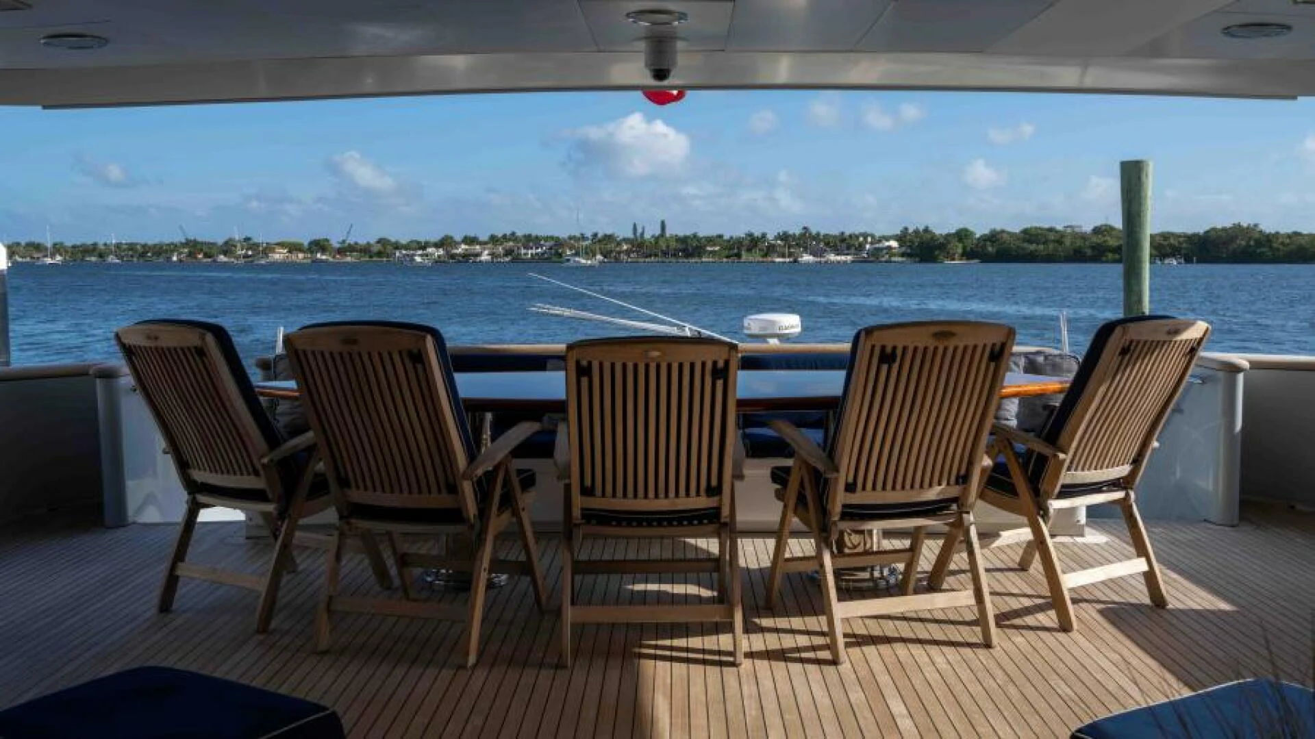 a deck with chairs and a table on it aboard ODIN Yacht for Sale
