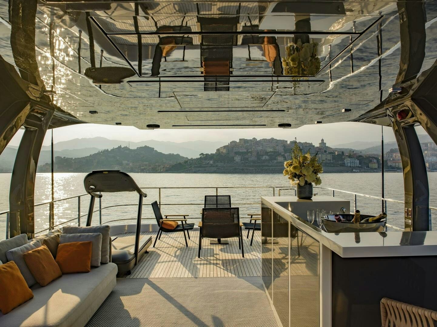 a room with a table chairs and a view of a mountain range aboard MARIA THERESA Yacht for Sale