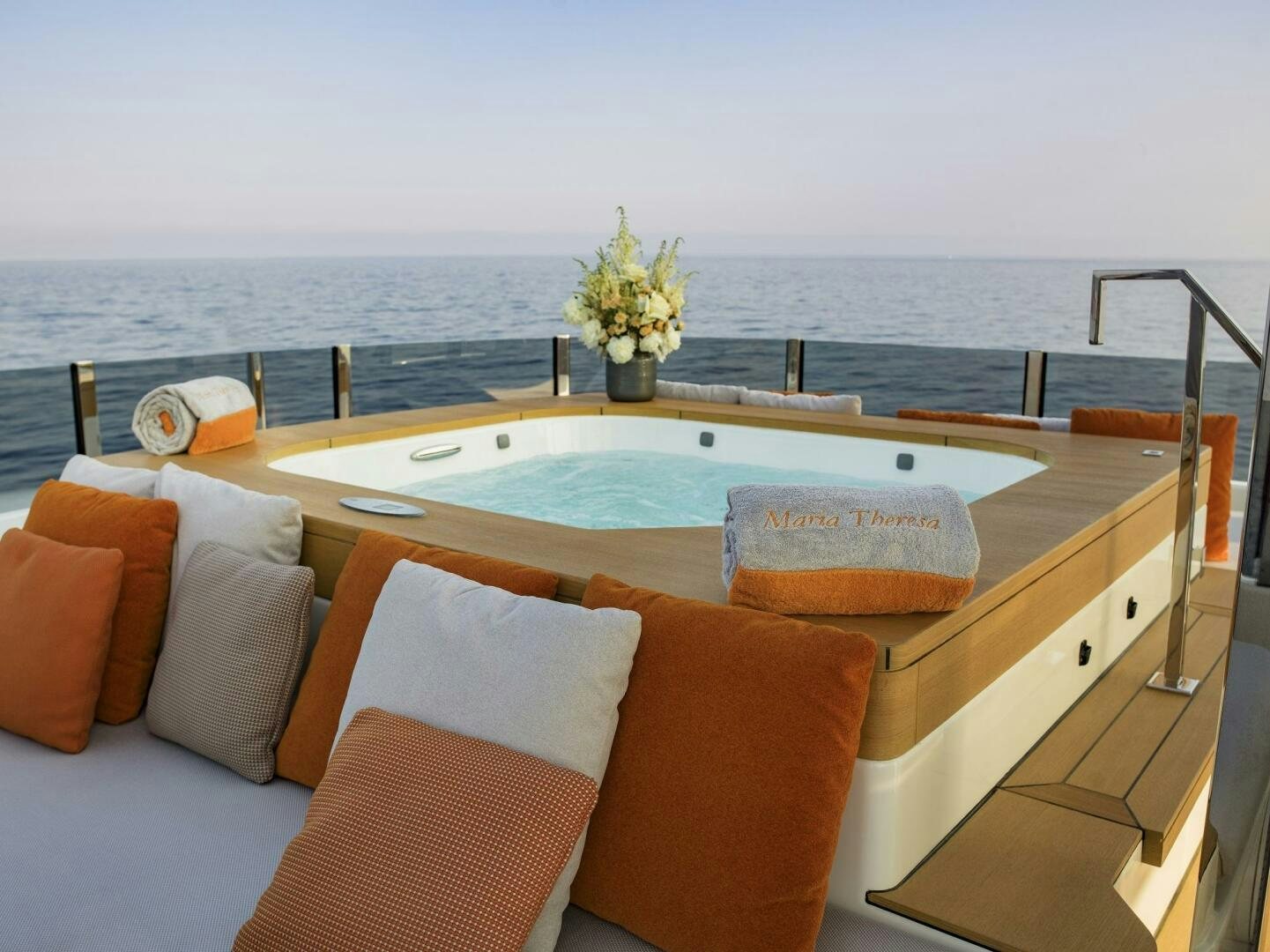 a large lounge chair on a balcony overlooking a body of water aboard MARIA THERESA Yacht for Sale