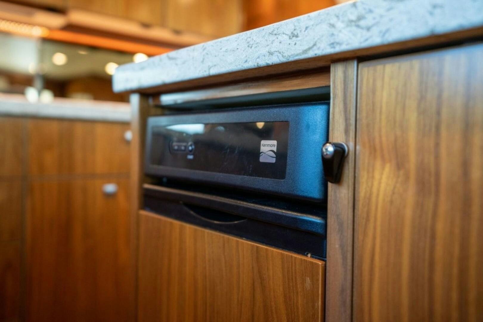 a black microwave on a wooden cabinet aboard WRAPPED UP Yacht for Sale