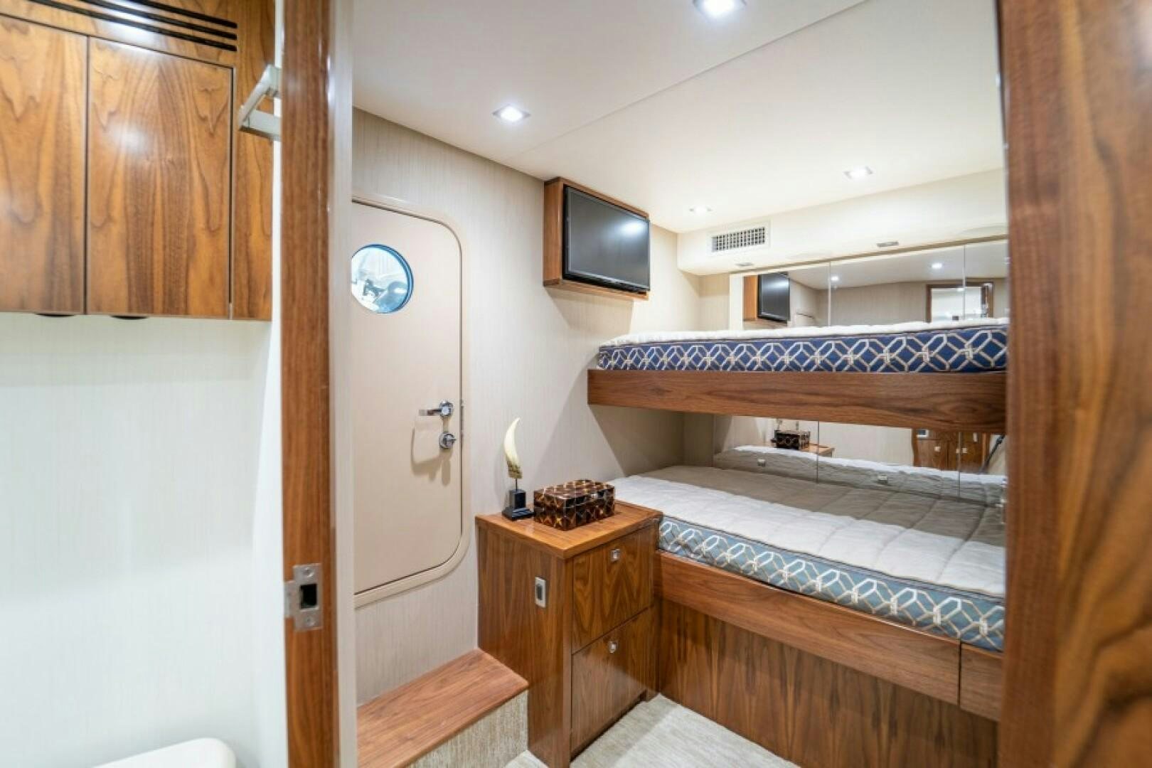 a room with a bed and a television on the wall aboard WRAPPED UP Yacht for Sale