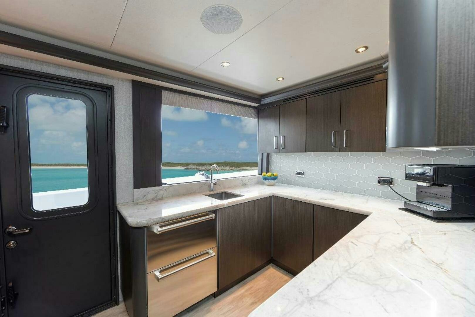 a kitchen with a large window aboard MEMENTO VIVERE Yacht for Sale