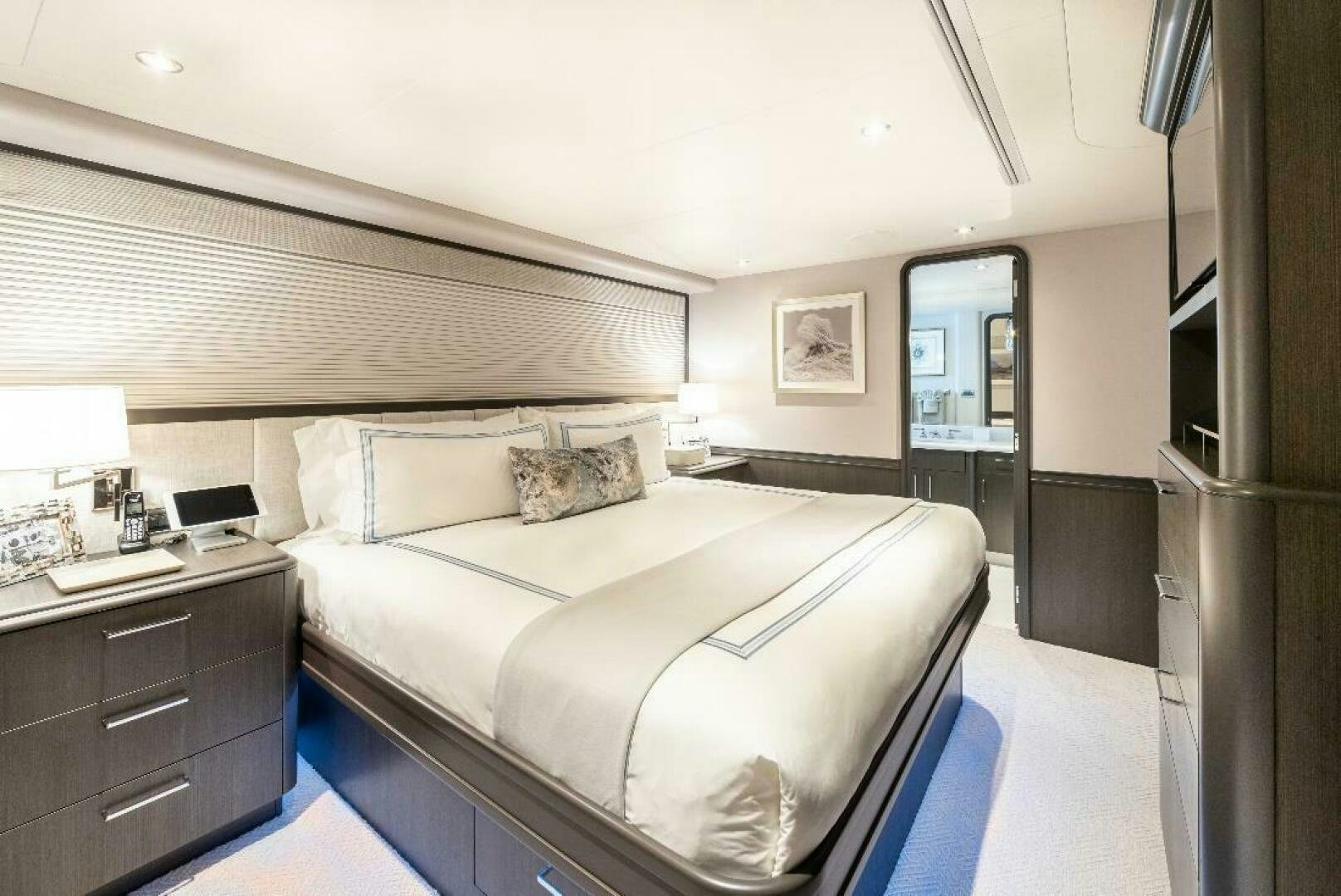 a bedroom with a bed and a desk aboard MEMENTO VIVERE Yacht for Sale