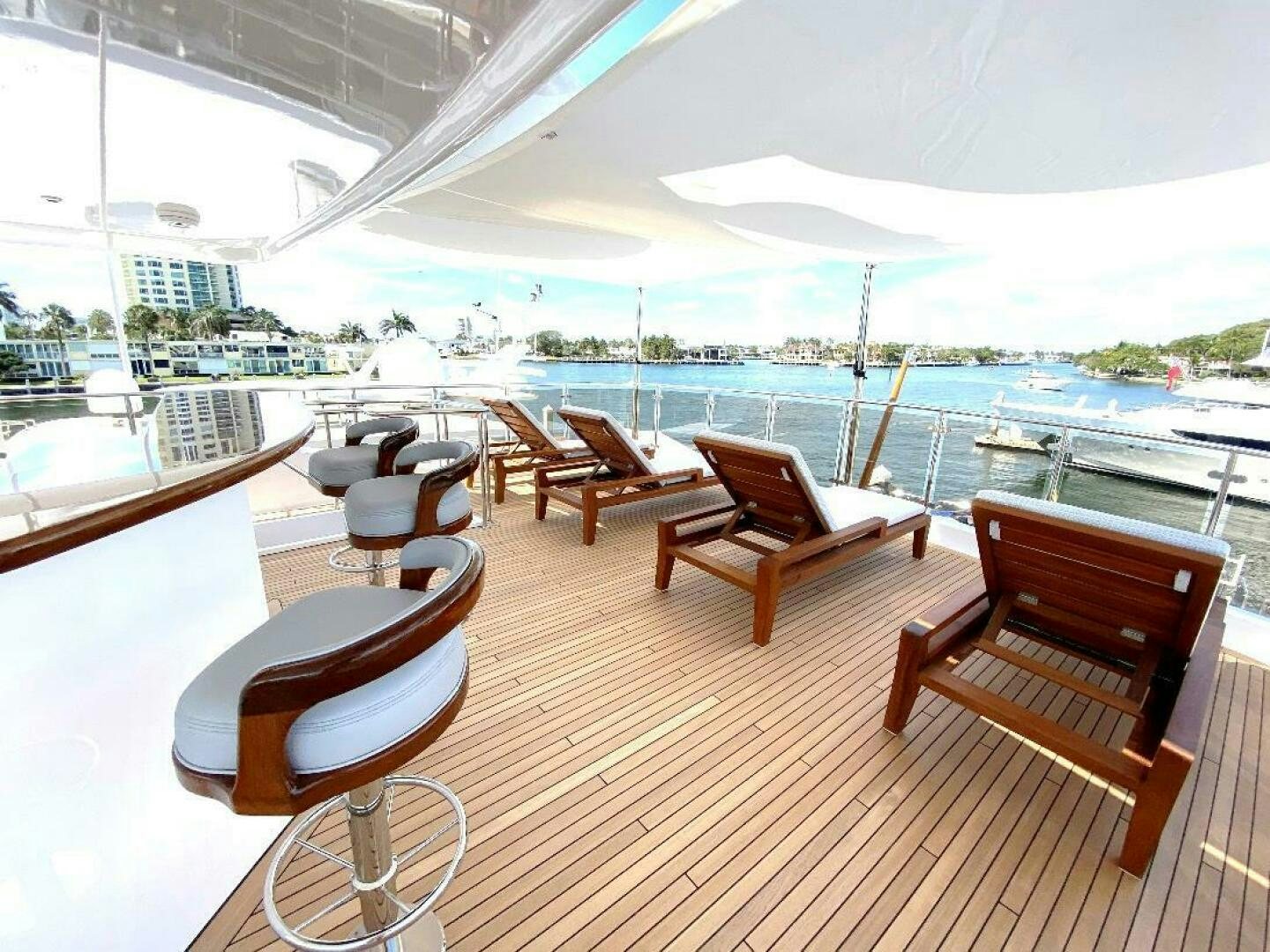 a deck with chairs and a table on it aboard MEMENTO VIVERE Yacht for Sale