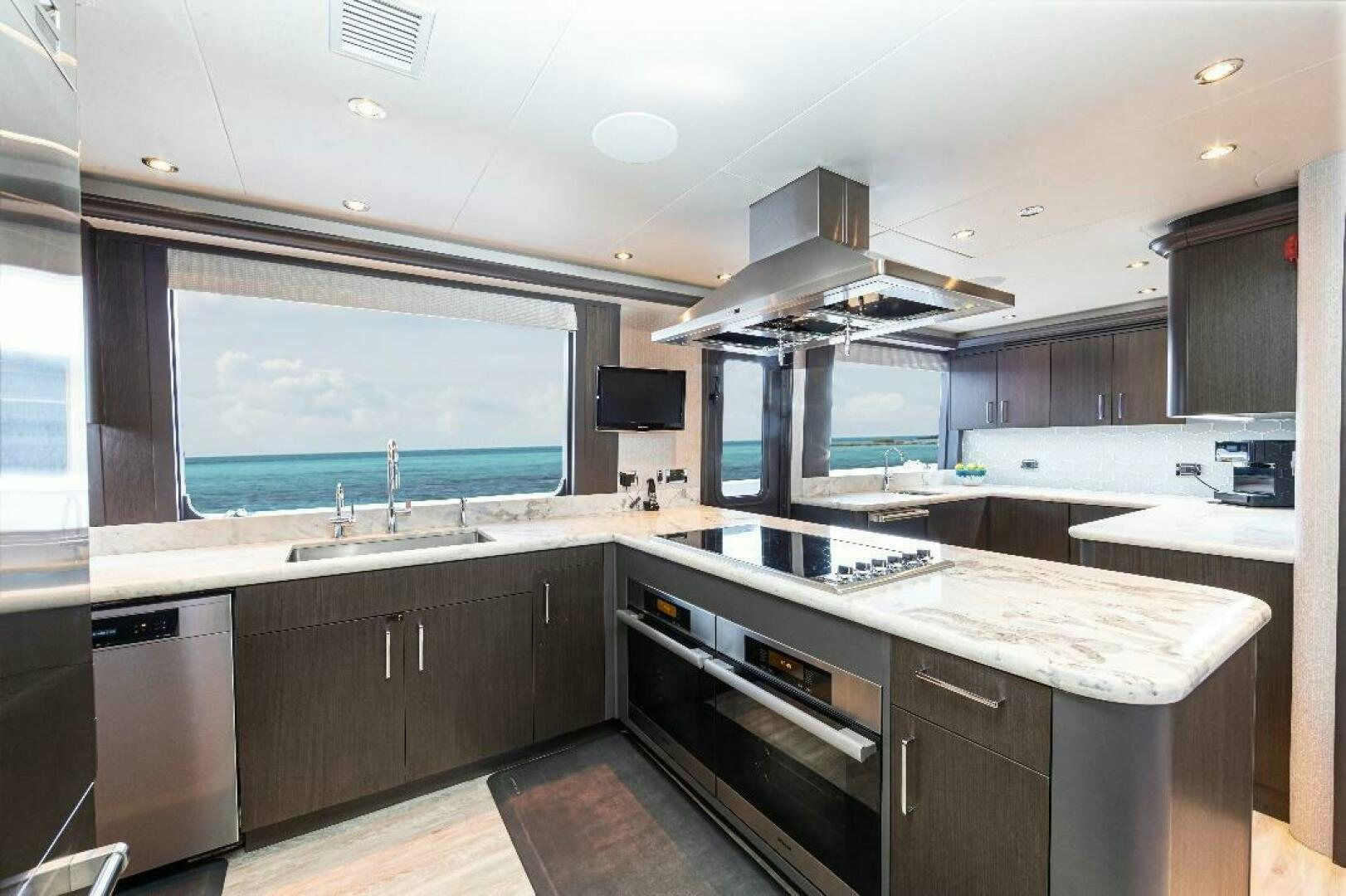 a kitchen with a large island aboard MEMENTO VIVERE Yacht for Sale