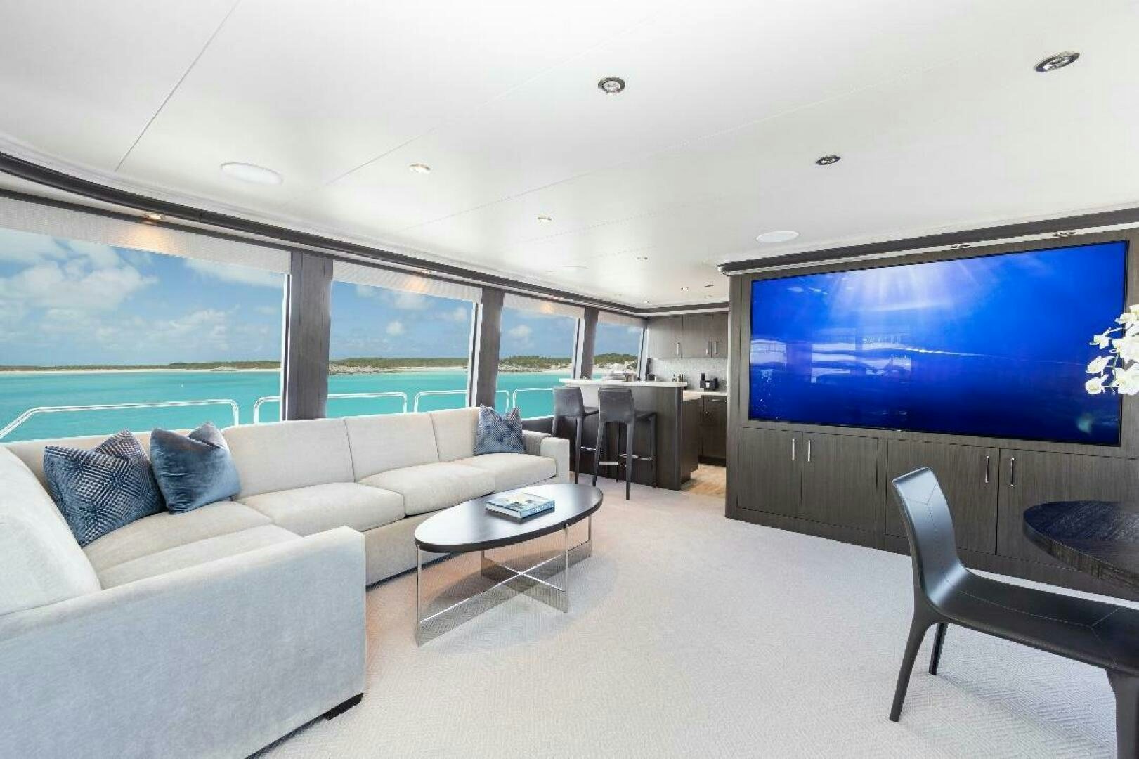 a living room with a large screen aboard MEMENTO VIVERE Yacht for Sale