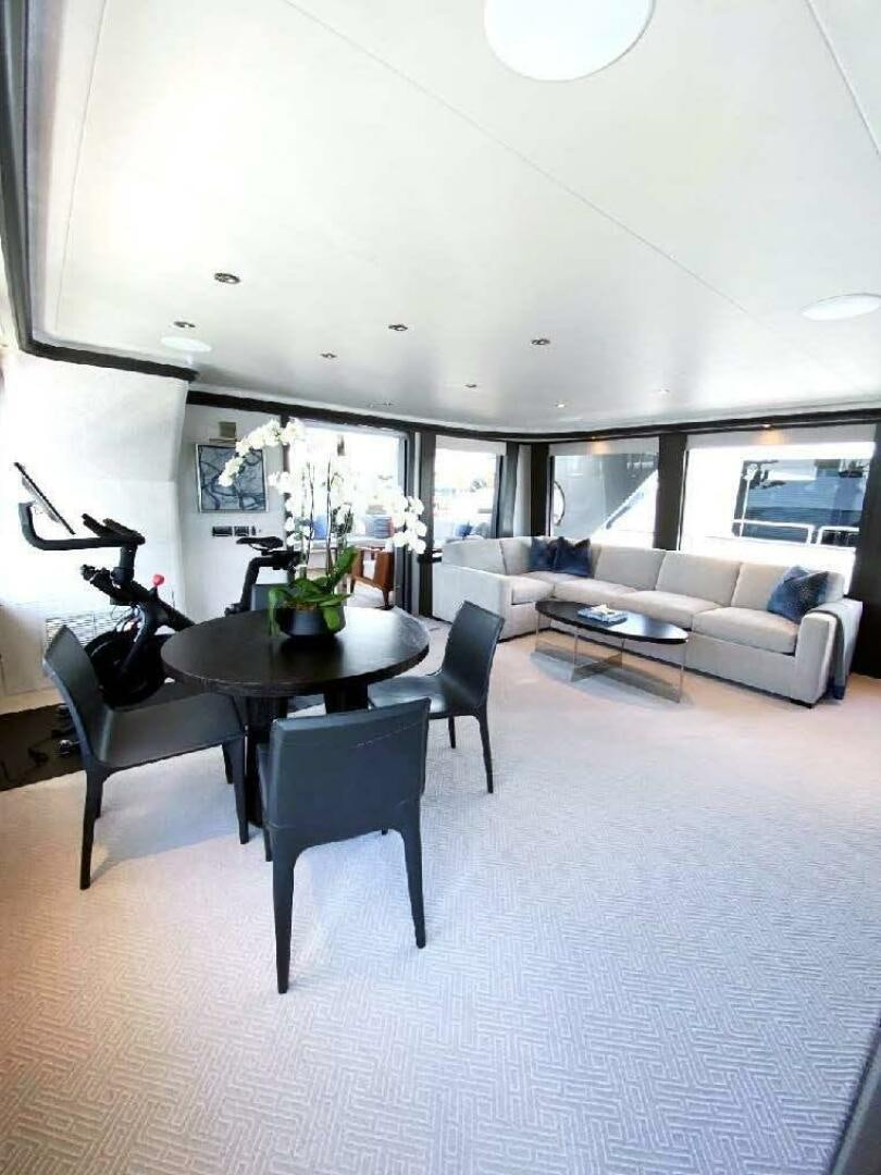 a living room with a table and chairs aboard MEMENTO VIVERE Yacht for Sale