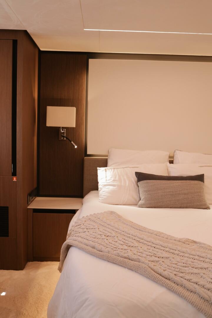 a bed with a lamp on the side aboard IL DISFRUTE Yacht for Sale