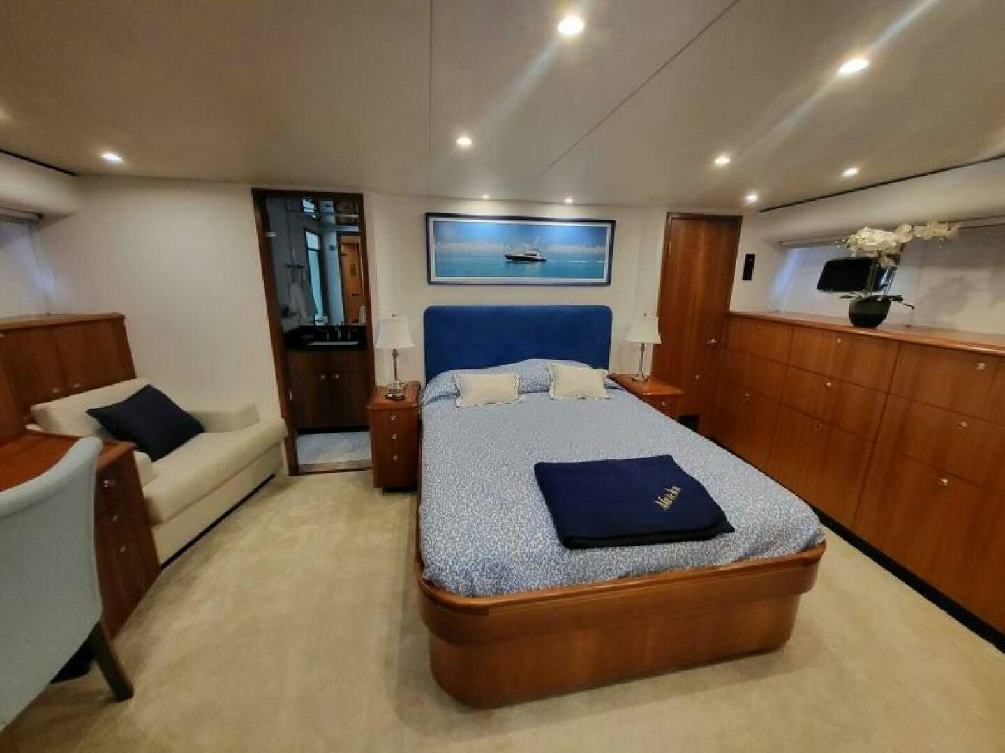 a bedroom with a bed and a chair aboard MAR JON Yacht for Sale