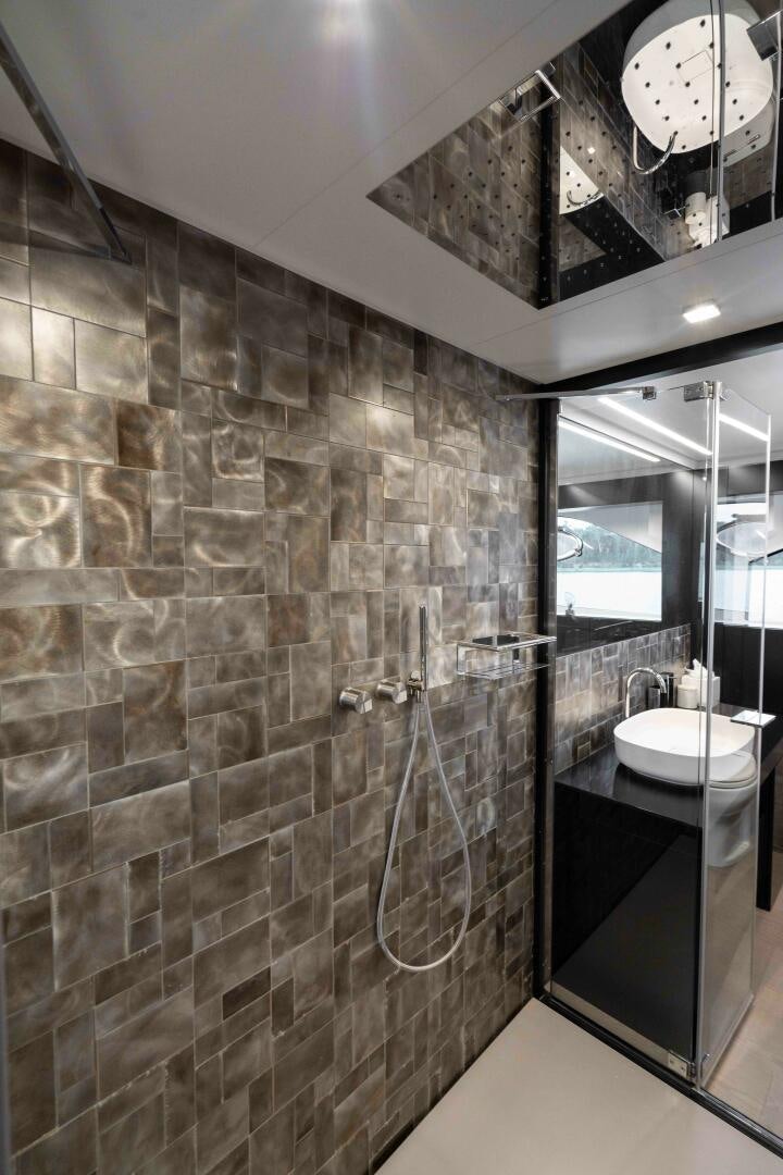 a bathroom with a stone wall aboard STALLION Yacht for Sale