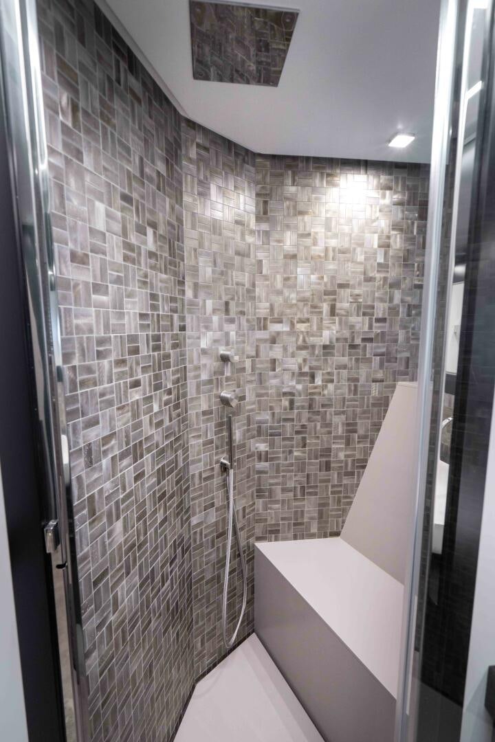 a bathroom with a tile wall aboard STALLION Yacht for Sale