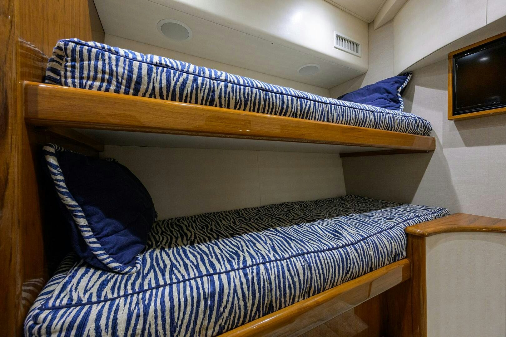 a bed with a blue and white striped comforter aboard TORTA Yacht for Sale