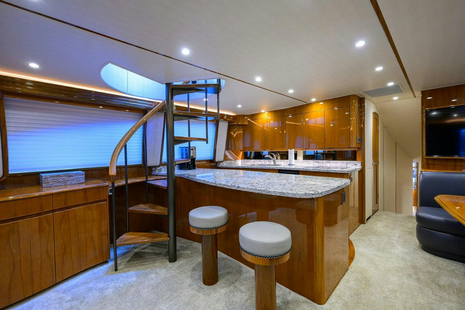 a large kitchen with a bar and stools aboard TORTA Yacht for Sale