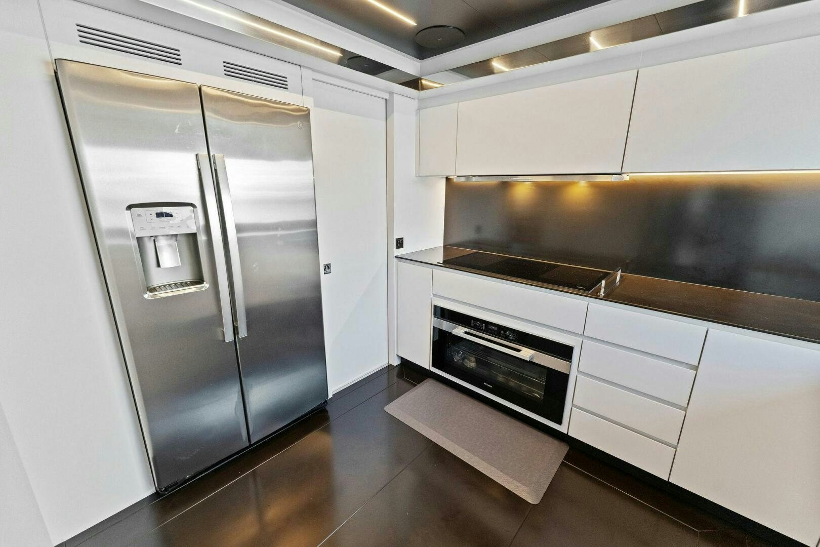 a kitchen with a stainless steel refrigerator aboard 110' RIVA DOLCEVITA 2024 Yacht for Sale