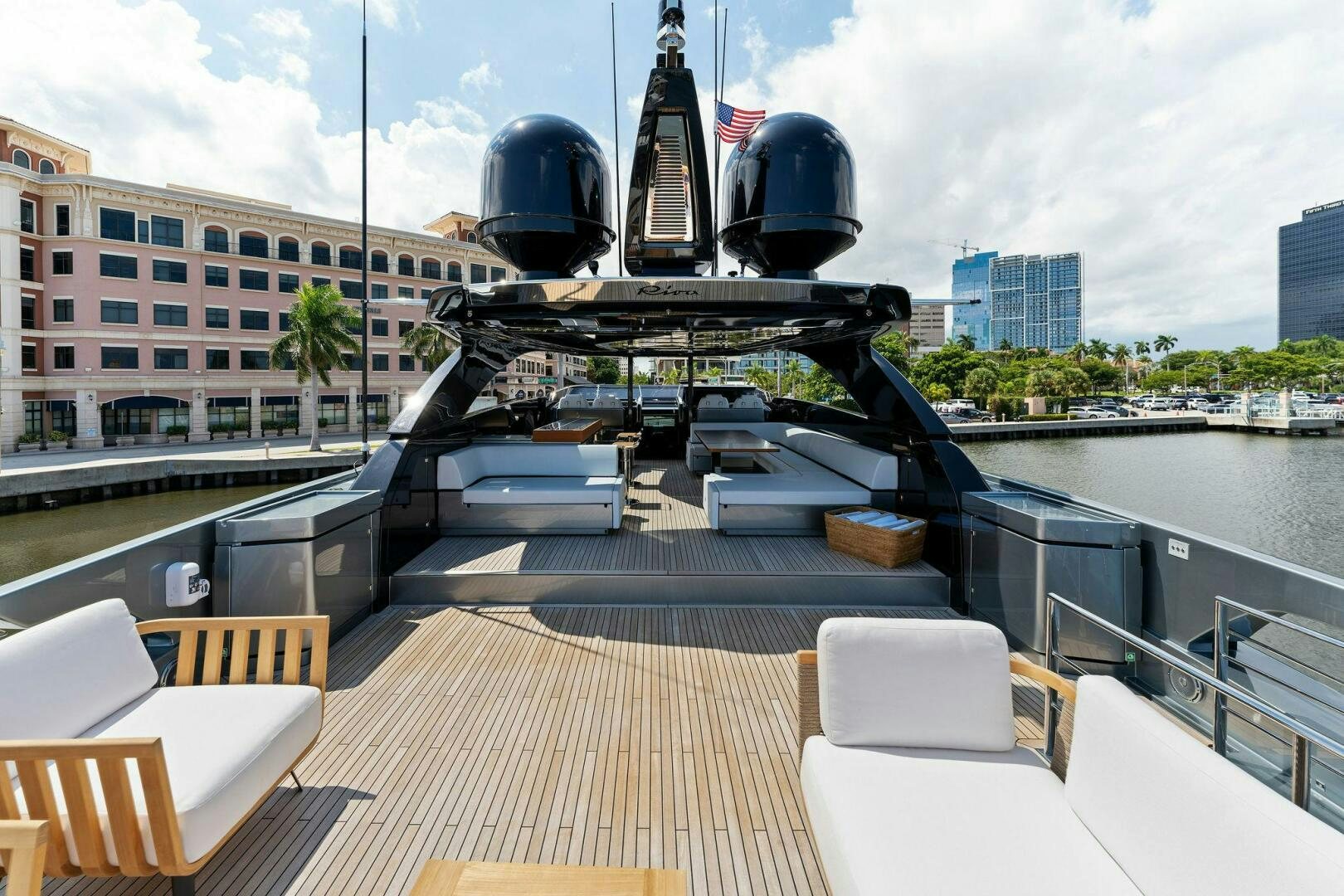 a deck with a large ship in the water and buildings in the background aboard 110' RIVA DOLCEVITA 2024 Yacht for Sale