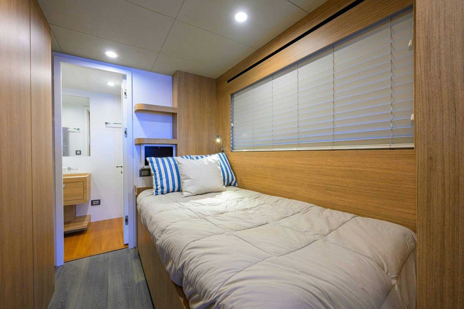 a bedroom with a bed and a window aboard AMORE Yacht for Sale