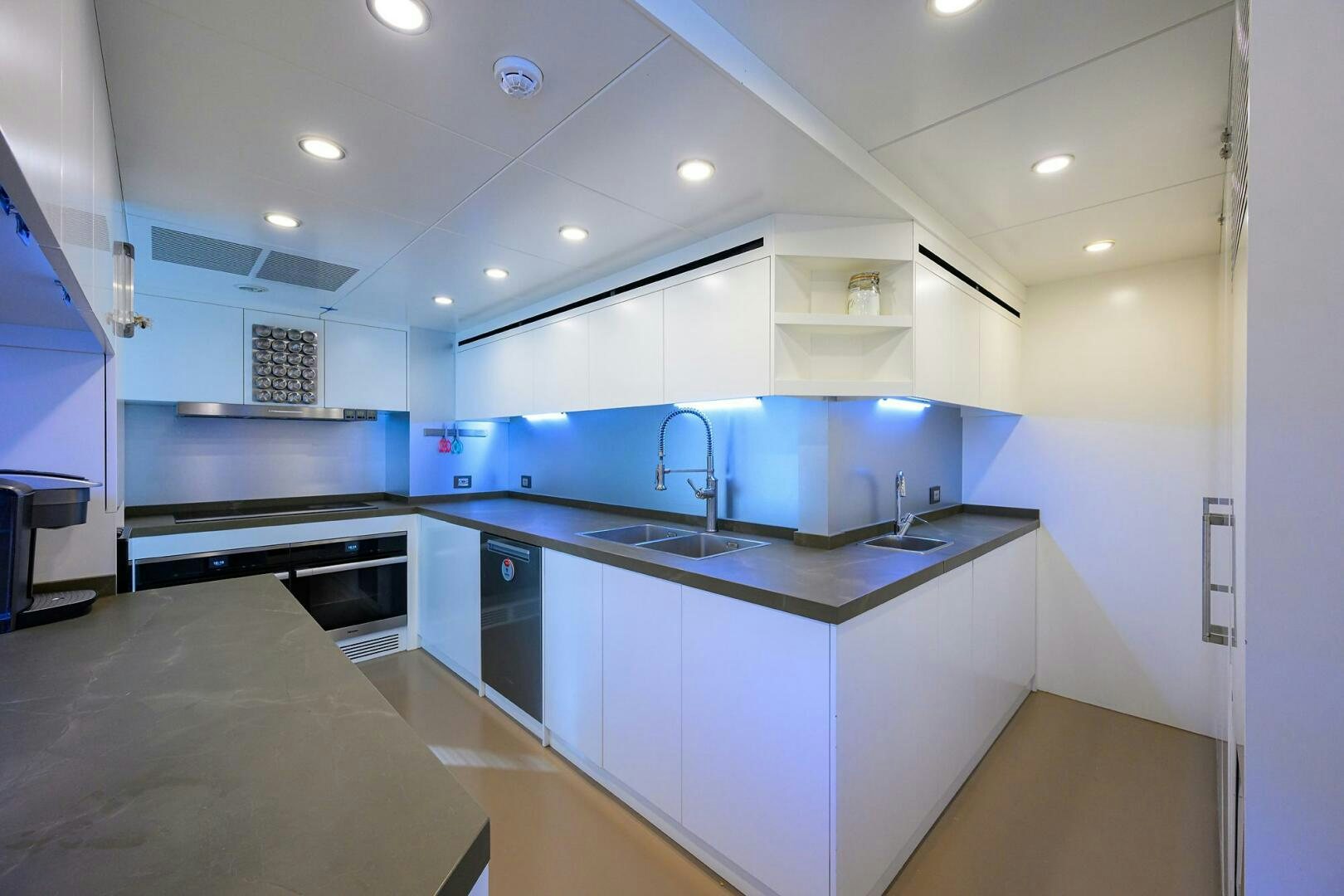 a kitchen with white cabinets aboard AMORE Yacht for Sale