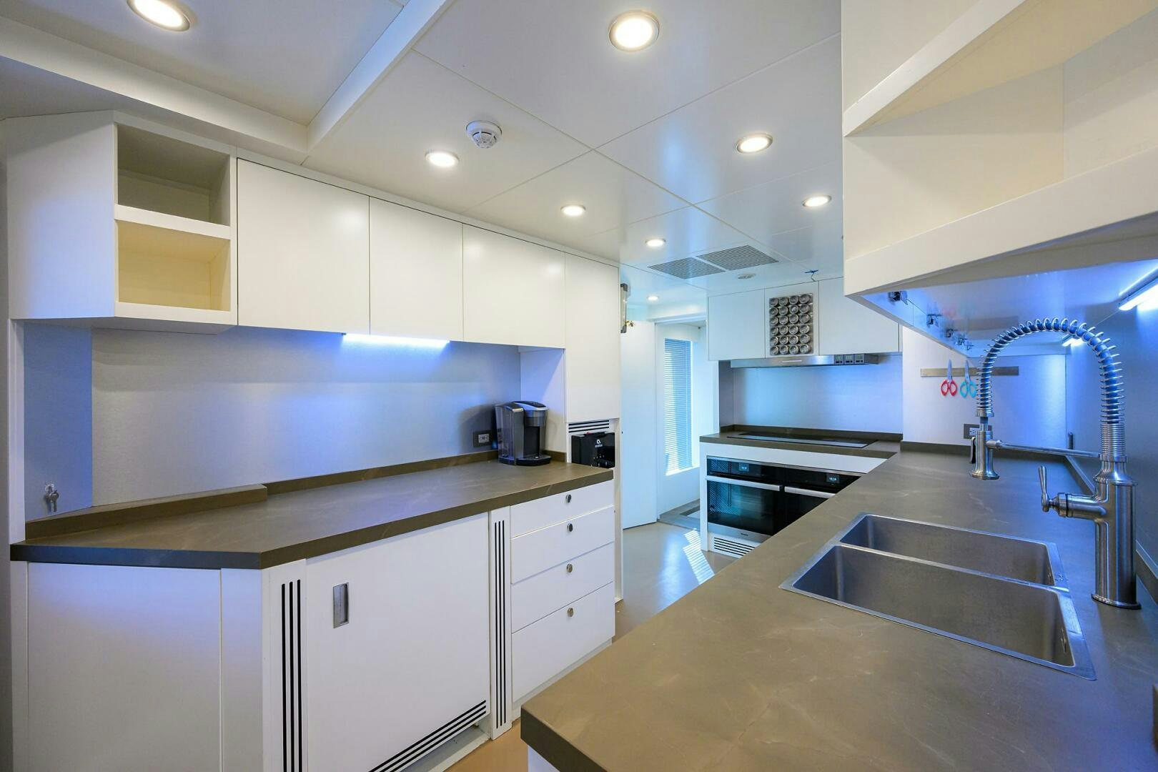 a kitchen with white cabinets aboard AMORE Yacht for Sale