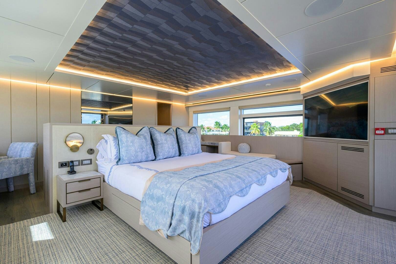 a bedroom with a bed and a chair aboard AMORE Yacht for Sale