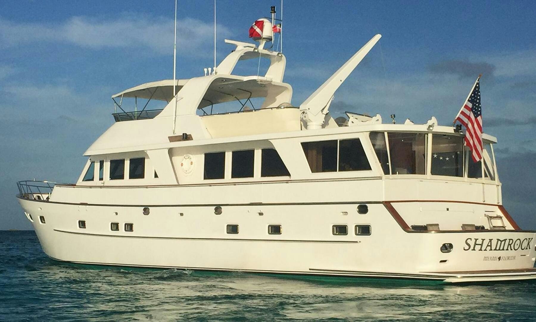 a white boat with a flag on the front aboard SHAMROCK Yacht for Sale