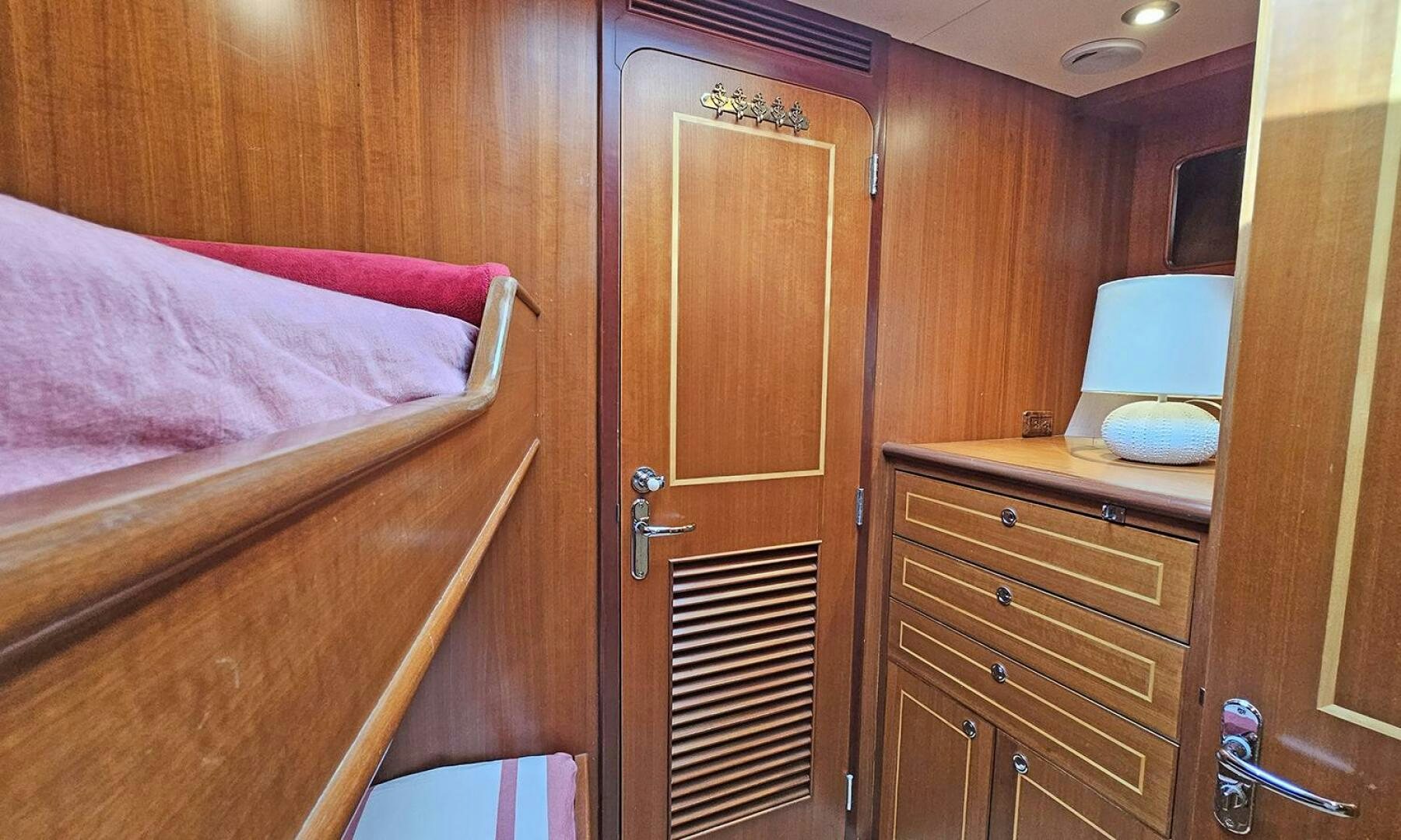a bed and a dresser in a room aboard SHAMROCK Yacht for Sale