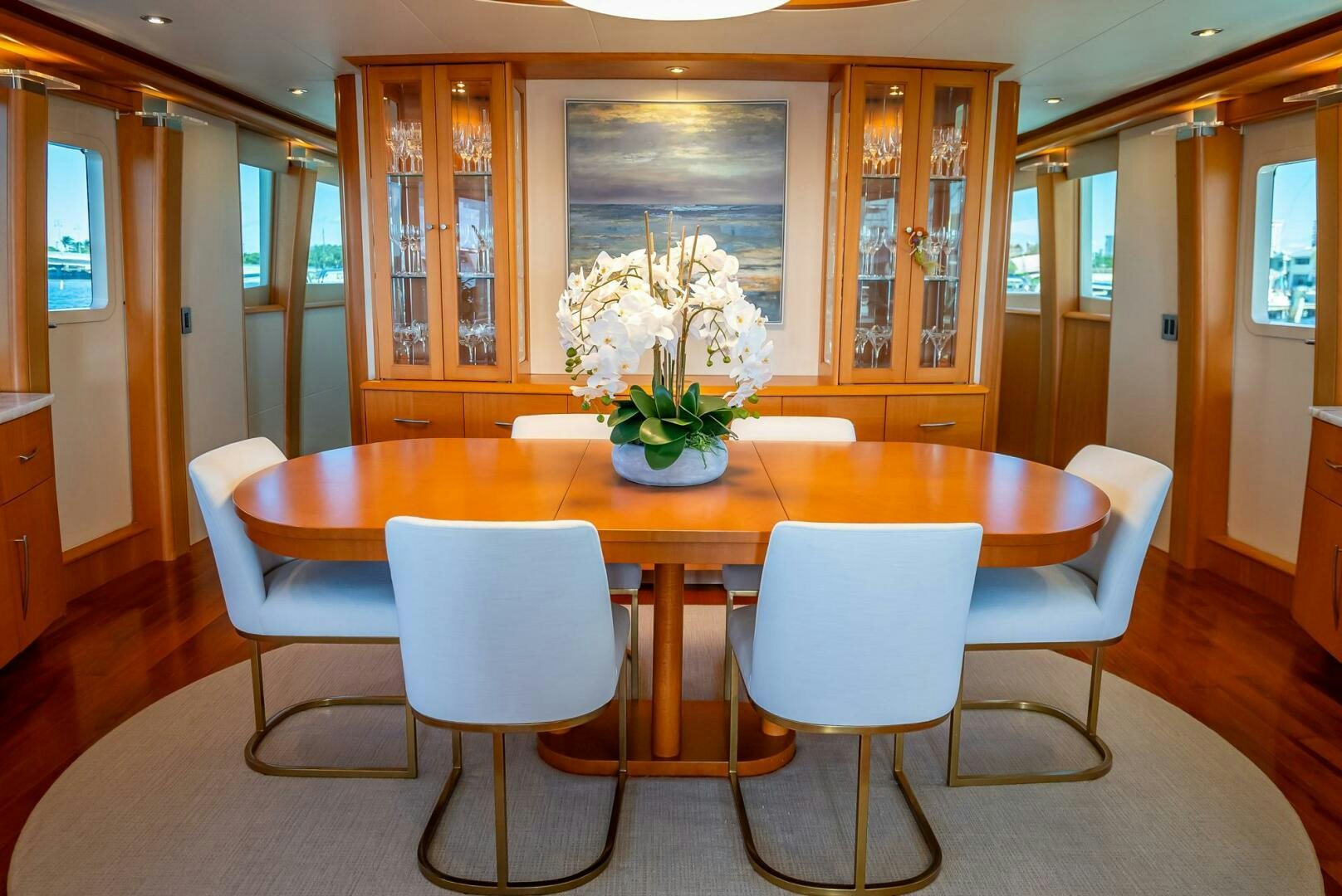 a dining table with white chairs aboard SERENITY Yacht for Sale