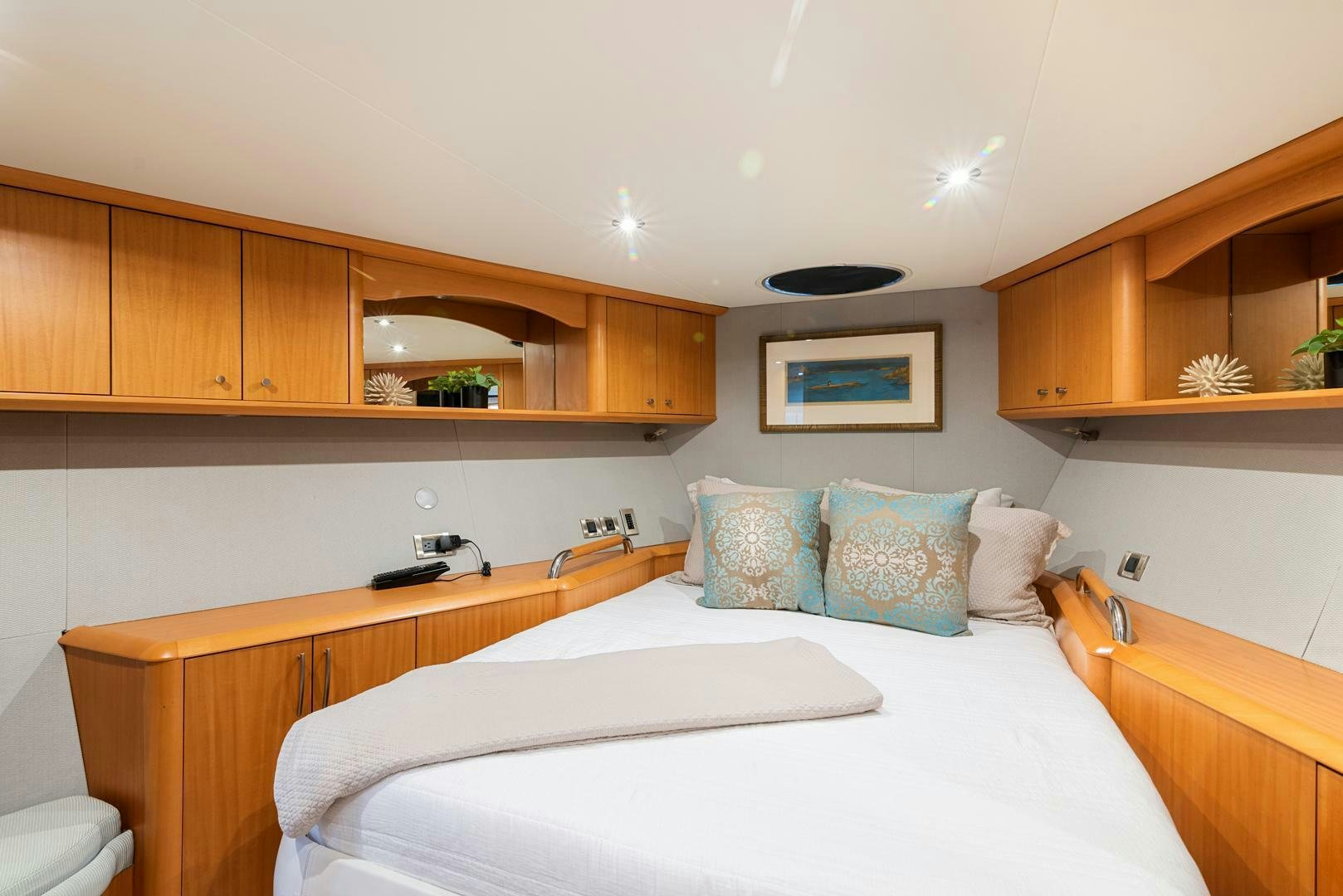 a bedroom with wooden cabinets aboard SERENITY Yacht for Sale