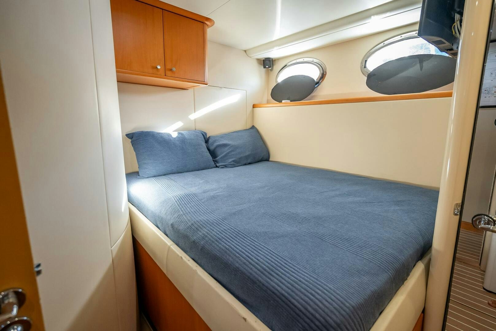 a bed with blue sheets aboard SERENITY Yacht for Sale