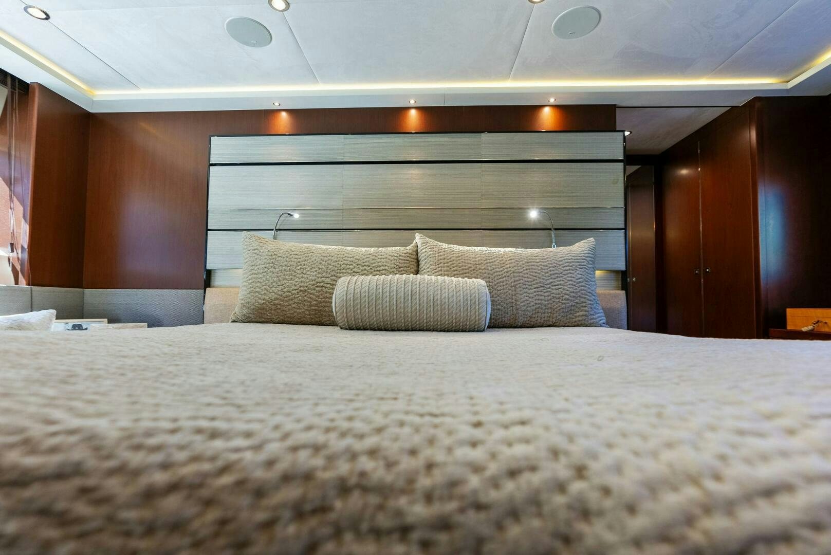 a bed with a white comforter aboard WOODY Yacht for Sale