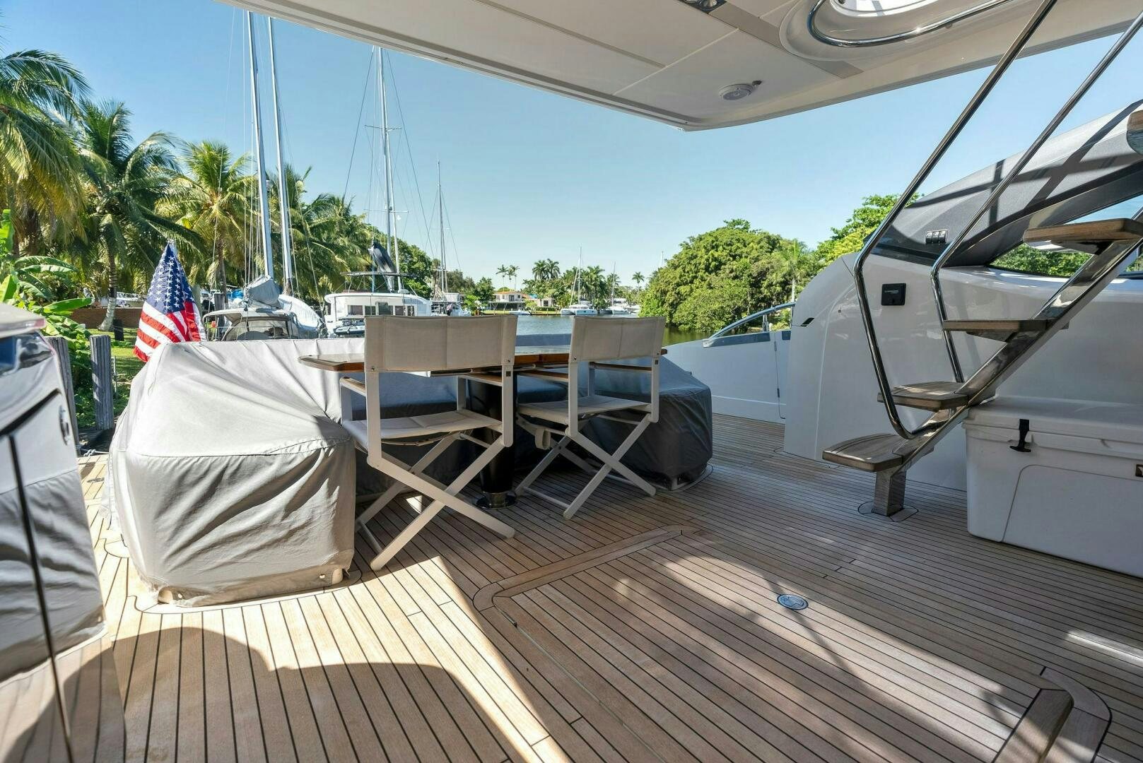 a deck with chairs and a flag on it aboard WOODY Yacht for Sale