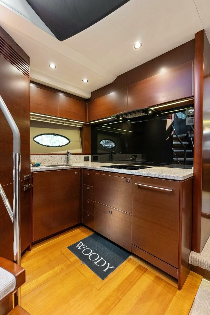 a kitchen with wooden cabinets aboard WOODY Yacht for Sale