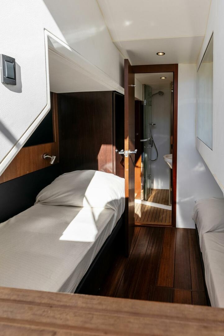 a room with a bed and a mirror aboard WOODY Yacht for Sale