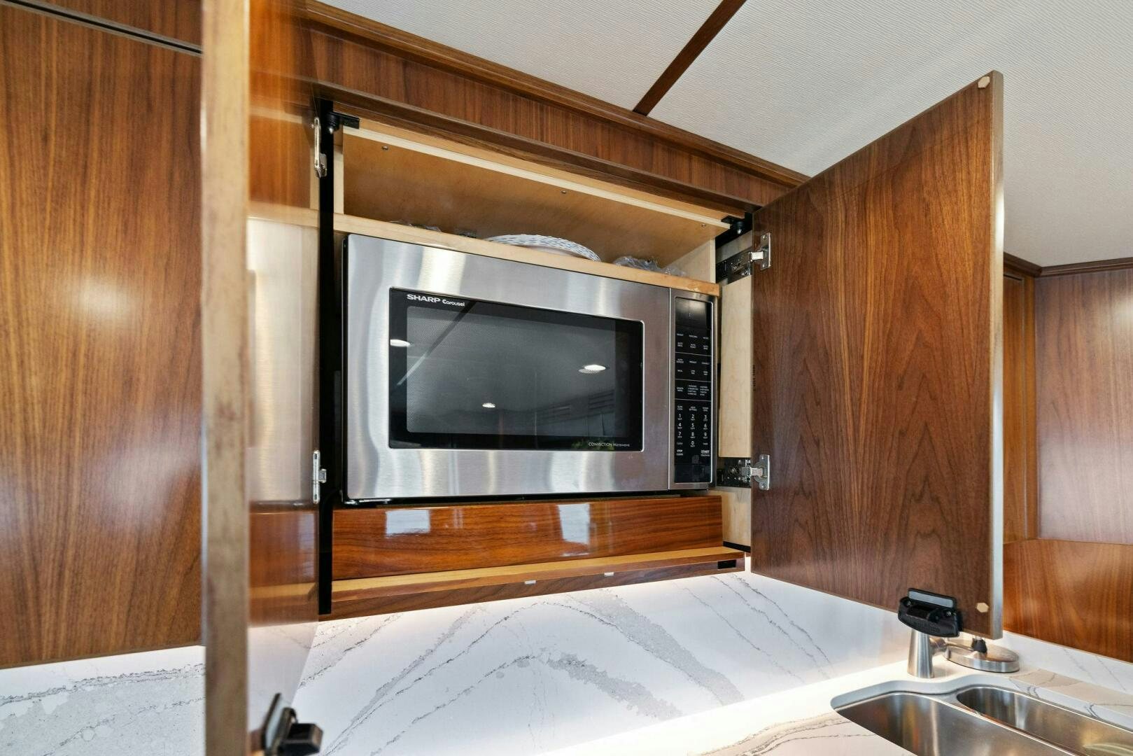 a microwave oven in a wooden cabinet aboard PLAN B Yacht for Sale
