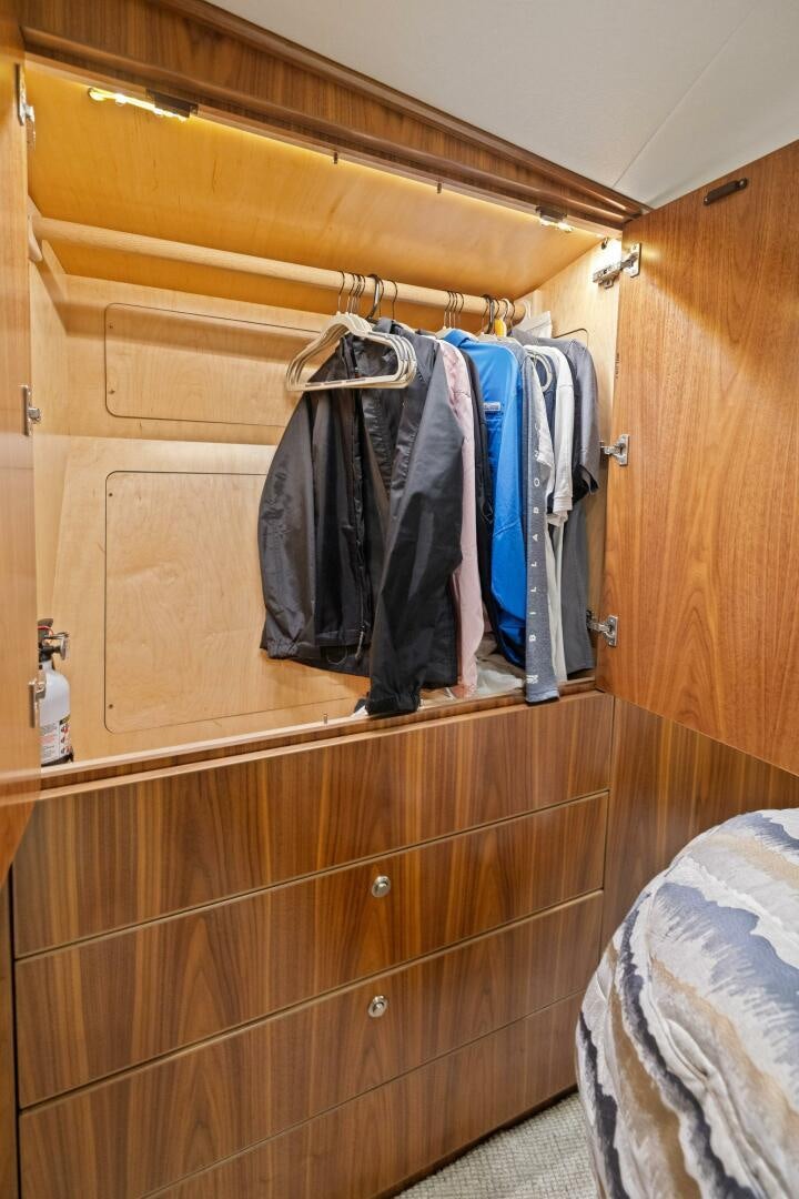 a closet with clothes on the wall aboard PLAN B Yacht for Sale