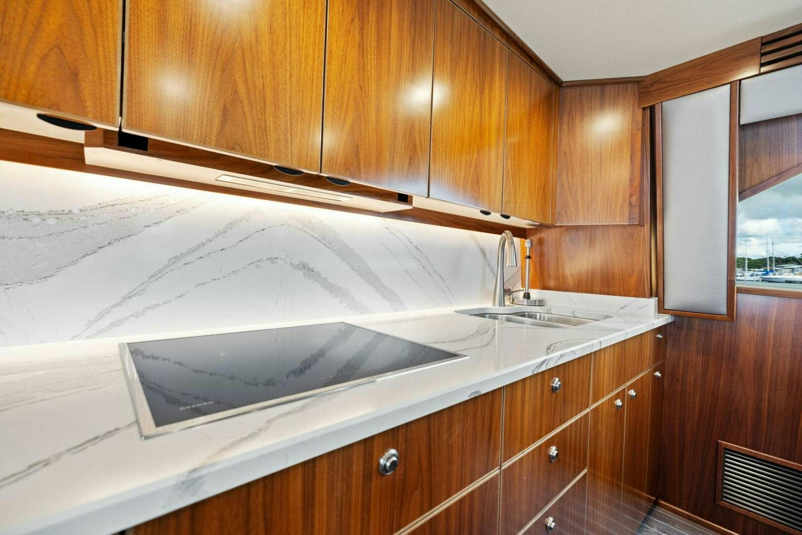 a kitchen with wooden cabinets aboard PLAN B Yacht for Sale
