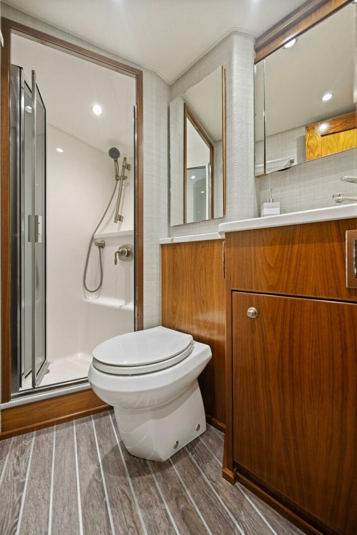 a bathroom with a toilet and a shower unit aboard PLAN B Yacht for Sale