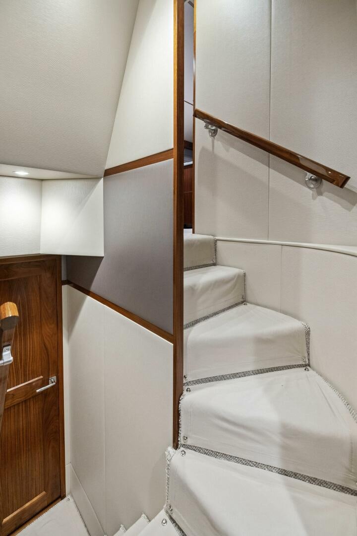 a white bed with a wooden frame aboard PLAN B Yacht for Sale