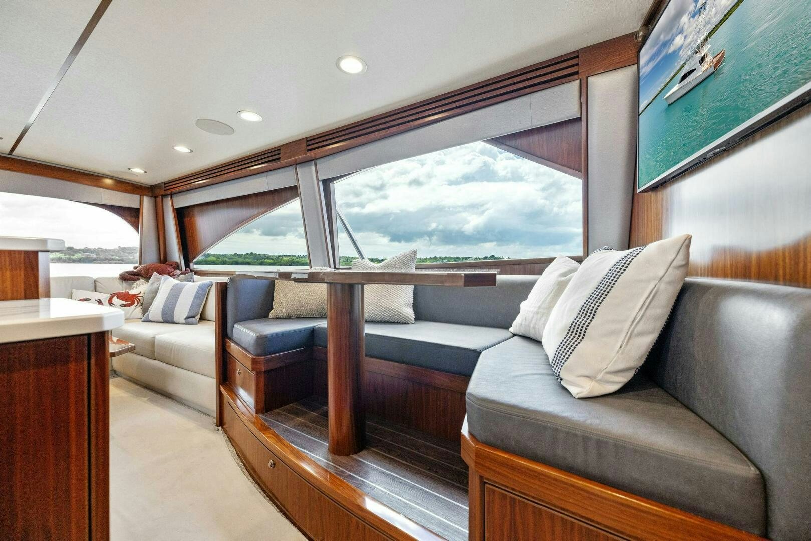 a room with a couch and a large window aboard PLAN B Yacht for Sale