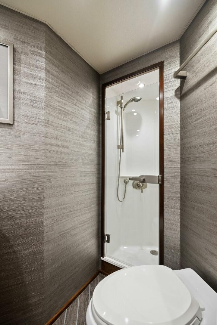 a bathroom with a glass shower door aboard PLAN B Yacht for Sale