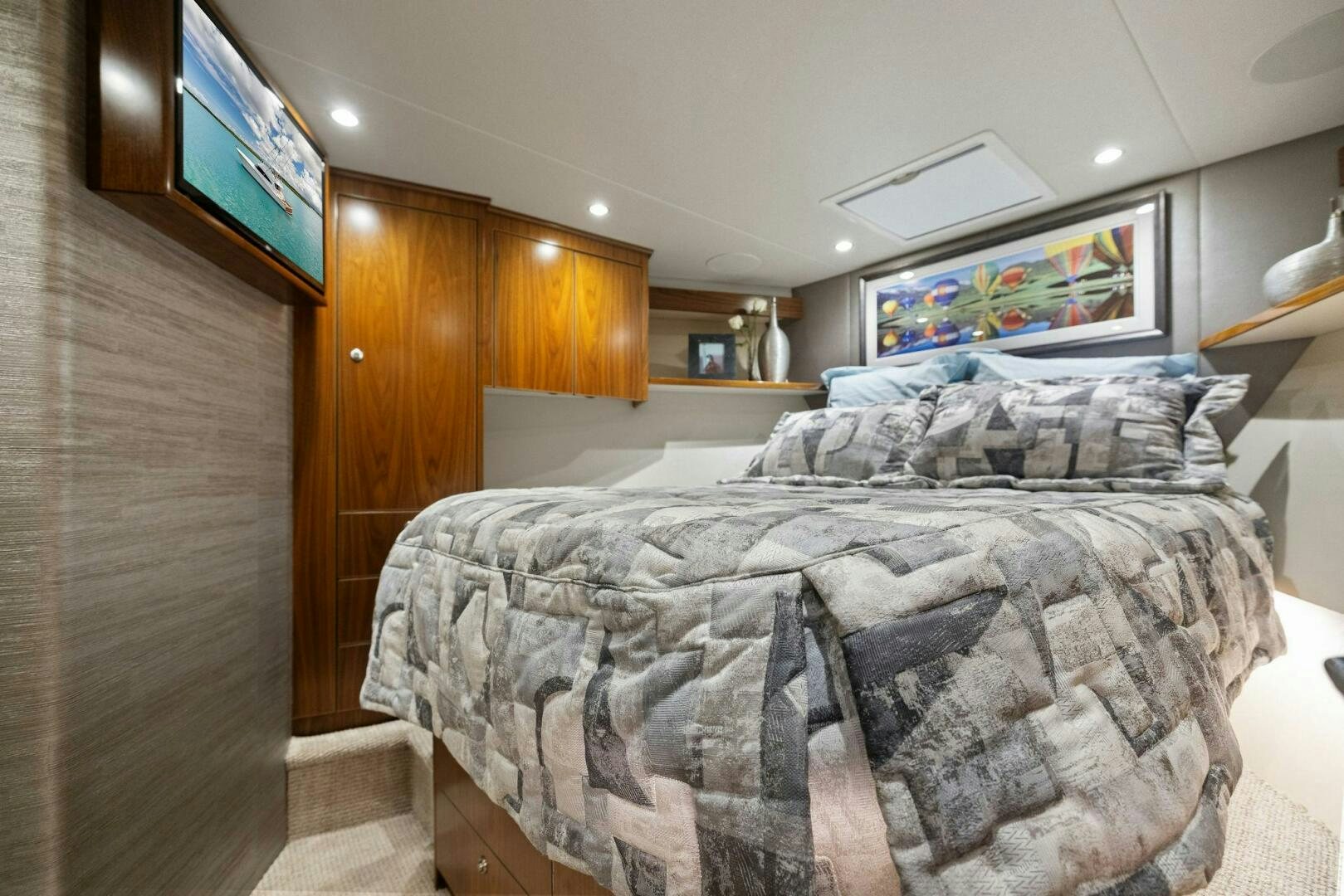 a bed with a television on the wall aboard PLAN B Yacht for Sale