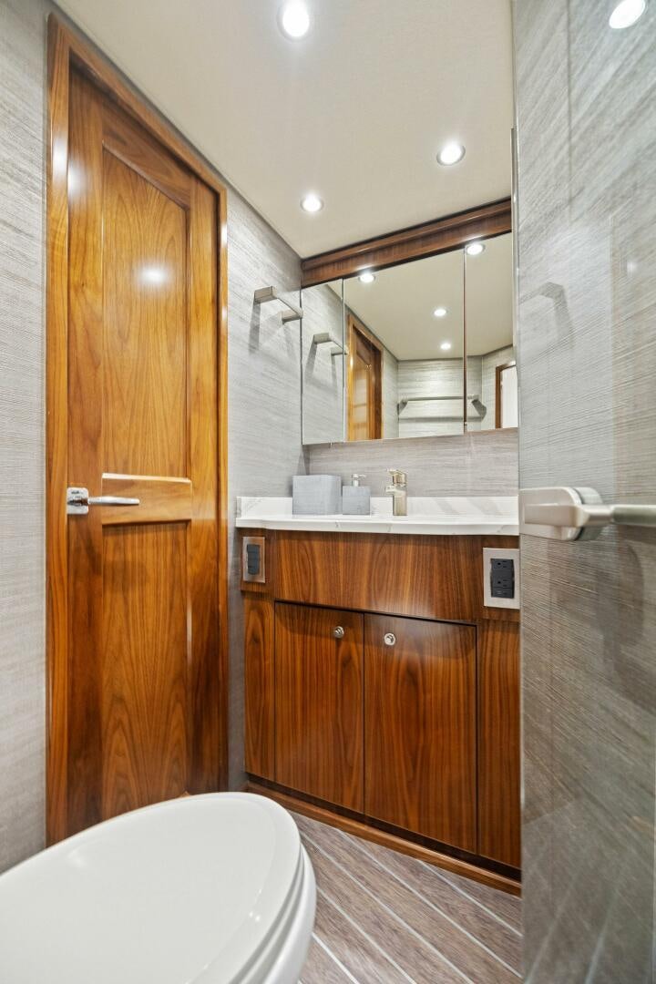a bathroom with a wood door aboard PLAN B Yacht for Sale